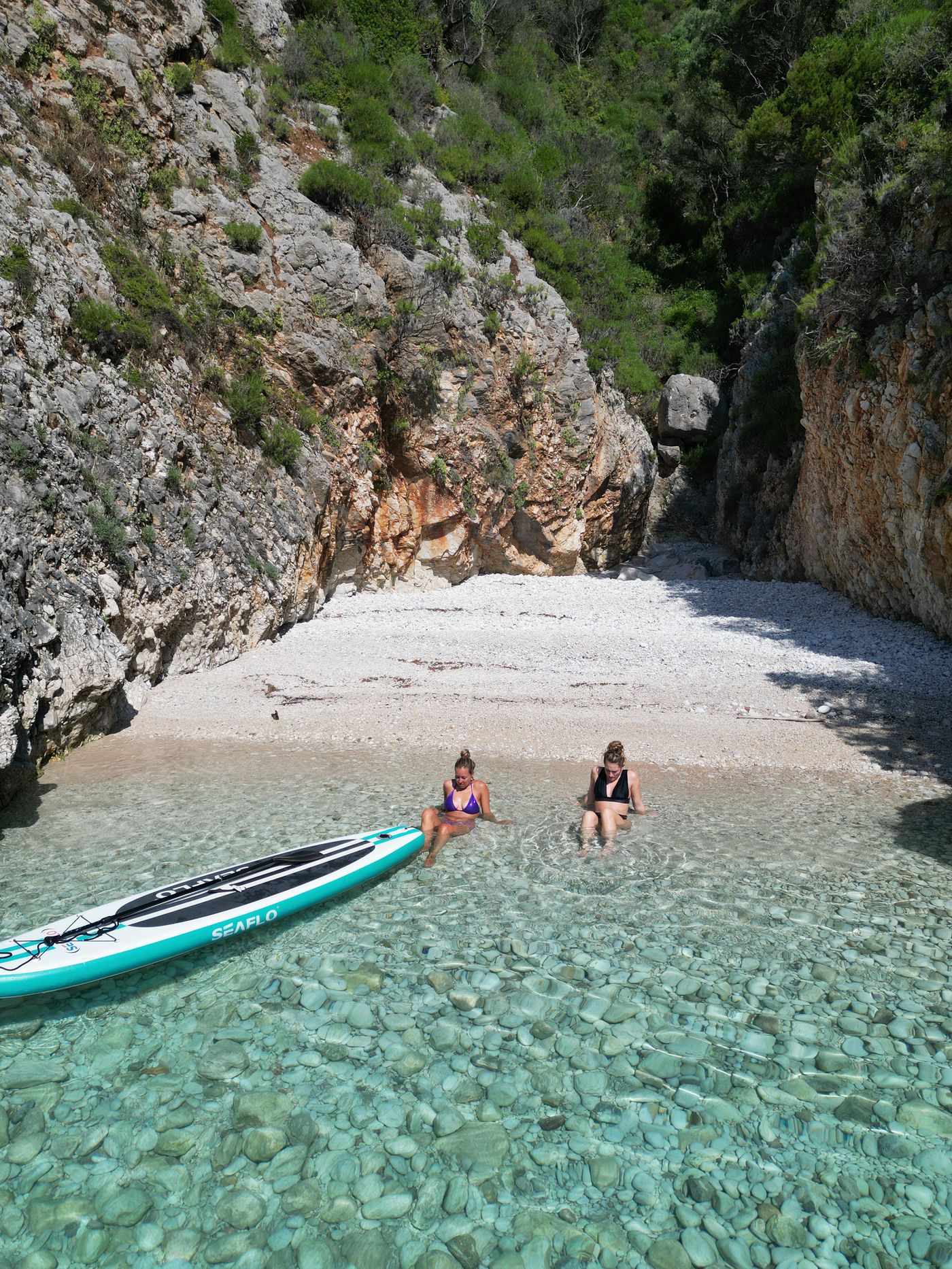 Two paddleboards on a hidden beach — drone